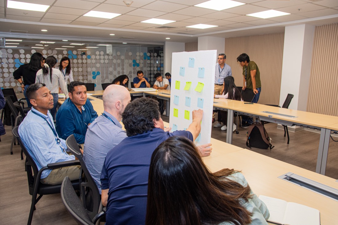 Participantes trabajando en equipo con un tablero de notas durante un módulo
